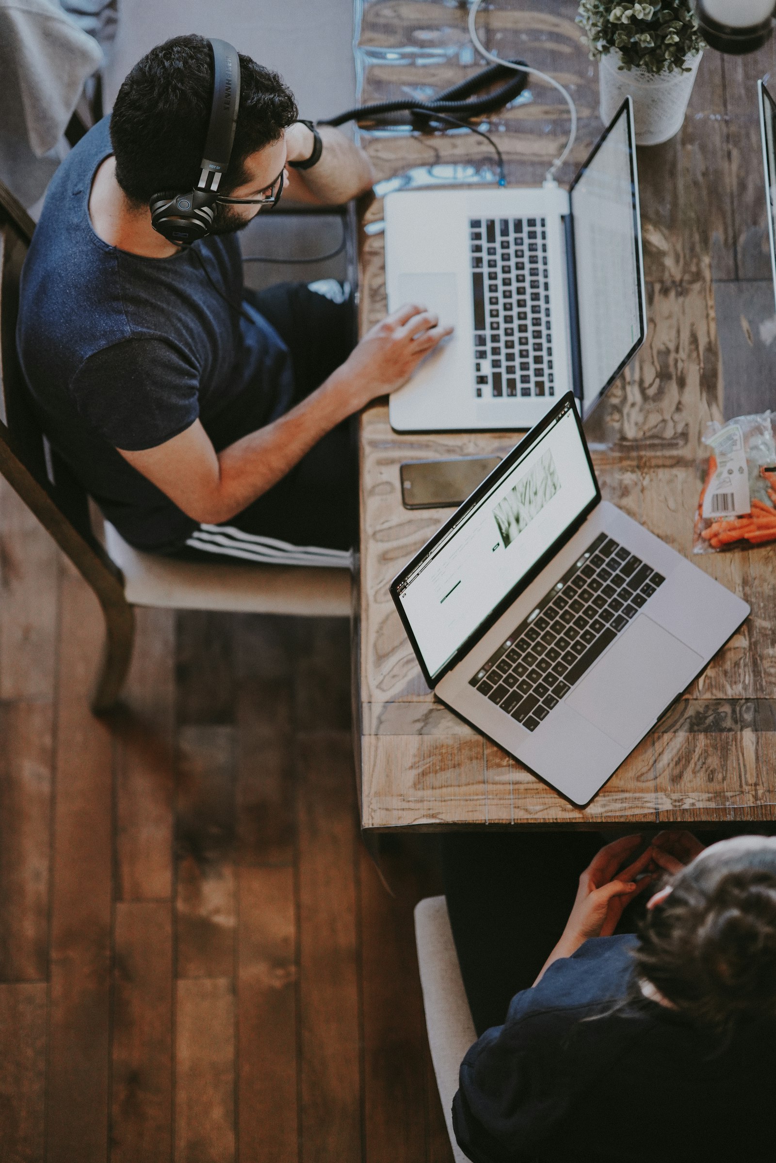 A support worker wearing a headset while working at a laptop